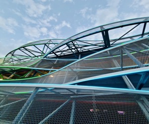 Overlapping cyan and green curves drawn through steel and sky